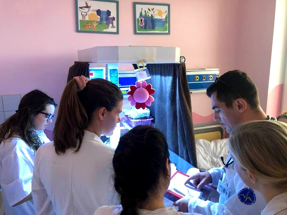 Charles University LF3 medical students in white coats on a pediatric ward at FNKV teaching hospital